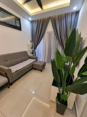 a living room with a couch and a plant at Awani3 Homestay Setapak, KL in Kuala Lumpur