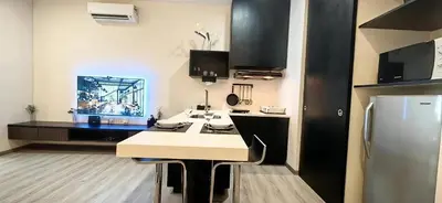 a small kitchen with a counter and a refrigerator at pertama residency jacuzzi projector 120