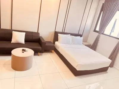 a room with a bed and a couch and a table at Chamber Luxury Suites Kuala Lampur in Kuala Lumpur
