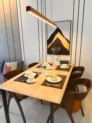 a wooden table with plates and glasses on it at Chamber Luxury Suites Kuala Lampur in Kuala Lumpur