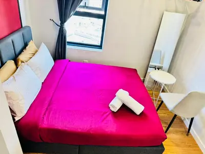 a red bed with two white towels on it at Chamber Luxury Suites Kuala Lampur in Kuala Lumpur