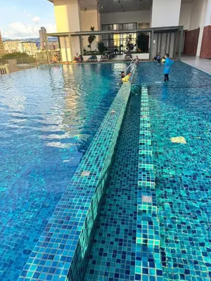 a swimming pool with blue tiles on the water at Chamber Luxury Suites Kuala Lampur in Kuala Lumpur