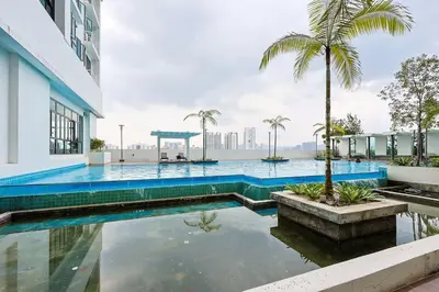 a swimming pool with a palm tree next to a building at One Maxim Sentul By LuxeStay in Kuala Lumpur