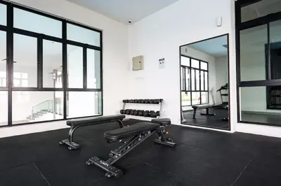 a gym with a bench and a mirror at One Maxim Sentul By LuxeStay in Kuala Lumpur