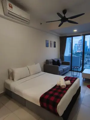 a bedroom with a bed and a couch and a ceiling fan at Luxe Colony By Urban Haven in Kuala Lumpur