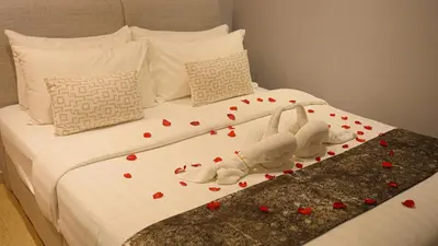a bed with hearts on it with two stuffed animals on it at Eaton Residences KLCC- JD World Homestay in Kuala Lumpur
