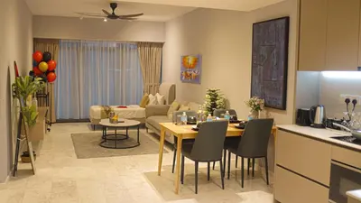 a kitchen and a living room with a table and chairs at Eaton Residences KLCC- JD World Homestay in Kuala Lumpur