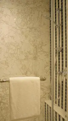 a bathroom with a shower with a white towel at Eaton Residences KLCC- JD World Homestay in Kuala Lumpur
