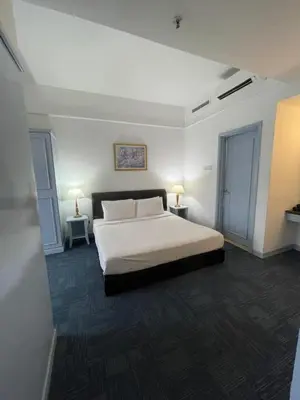 a bedroom with a white bed and two tables at Kuala Lumpur City Apartment Times Square in Kuala Lumpur