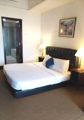 a bedroom with a large white bed with two lamps at Kuala Lumpur City Apartment Times Square in Kuala Lumpur