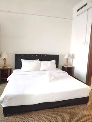 a bedroom with a large white bed with two lamps at Kuala Lumpur City Apartment Times Square in Kuala Lumpur