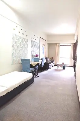 a room with a bed and chairs and a living room at Kuala Lumpur City Apartment Times Square in Kuala Lumpur