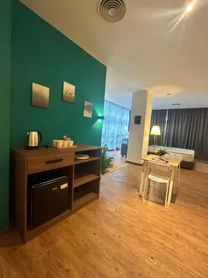 a living room with a green wall and a table at Premium One Bedroom Condo at Bangsar Trade Centre in Kuala Lumpur