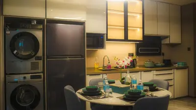 a kitchen with a table with chairs and a dishwasher at Imperial Residences KLCC - JD World Homestay in Kuala Lumpur