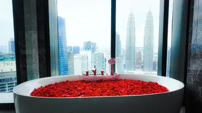 a bath tub filled with red roses in front of a window at Imperial Residences KLCC - JD World Homestay in Kuala Lumpur