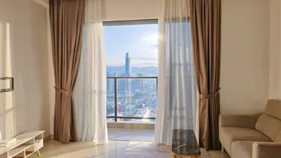 a living room with a couch and a large window at Trion KL Skyline Suites in Kuala Lumpur