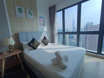 a bedroom with a white bed with a large window at The Wisma INFINITUM BY KL in Kuala Lumpur