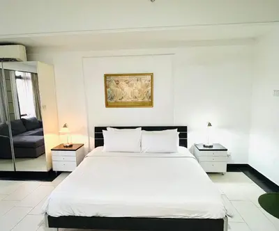 a white bedroom with a large bed and a couch at Max suites in Kuala Lumpur