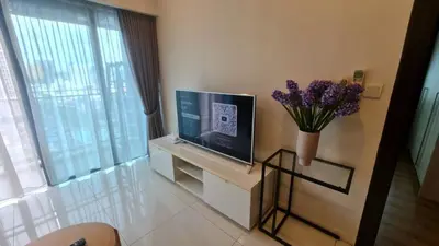 a living room with a television and a vase of flowers at Summer Suites Residences KLCC in Kuala Lumpur