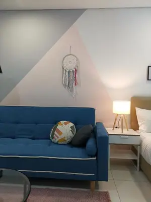 a blue couch in a room with a bed at Summer Suites Residences KLCC in Kuala Lumpur
