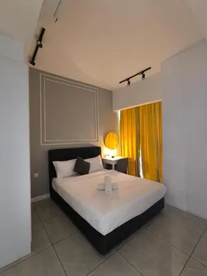 a bedroom with a bed and a table with a lamp at The Bukit Bintang Near pavilion Axon Residence KL in Kuala Lumpur