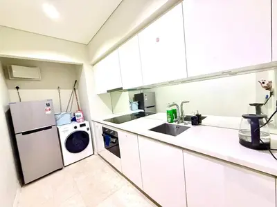 a kitchen with a refrigerator and a washing machine at sky suites klcc by Natasya in Kuala Lumpur