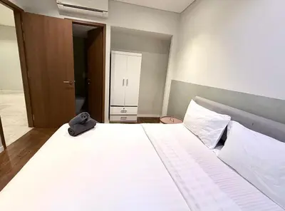 a bedroom with a large bed with a bag on it at sky suites klcc by Natasya in Kuala Lumpur