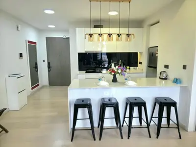 a kitchen with a large white island with four bar stools at A1 Hospitality At Star Residence KLCC in Kuala Lumpur