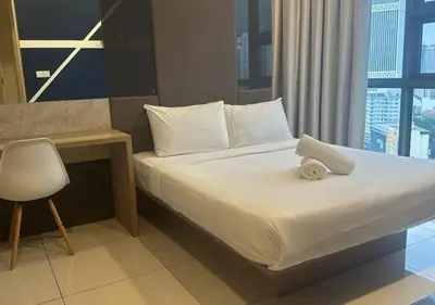 a bedroom with a bed with a desk and a chair at Robertson By Sahara Urban Oasis in Kuala Lumpur