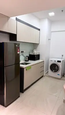 a kitchen with a refrigerator and a washing machine at Colony Luxe By Swift Homes in Kuala Lumpur