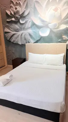a bed in a room with a painting of flowers at Colony Luxe By Swift Homes in Kuala Lumpur