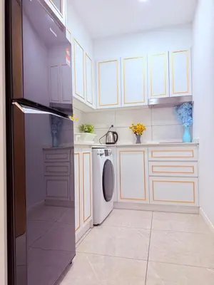 a kitchen with white cabinets and a washer and dryer at Aurora by comfort in Kuala Lumpur