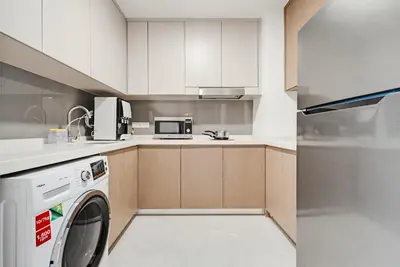 a kitchen with a washer and a washing machine at Earthy 2BR @ Agile BB | Wi-Fi + Netflix in Kuala Lumpur