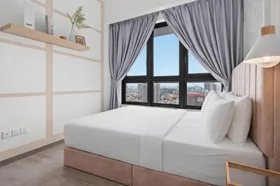 a bedroom with a large white bed with a window at Earthy 2BR @ Agile BB | Wi-Fi + Netflix in Kuala Lumpur