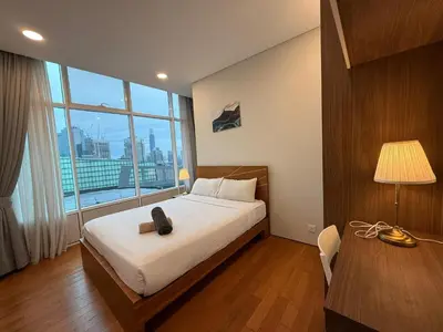 a bedroom with a bed with a cat sitting on it at Sky Suits By White Houze in Kuala Lumpur