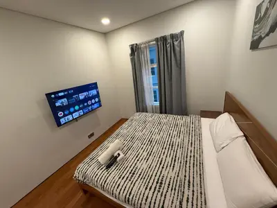 a bedroom with a bed and a tv on the wall at Sky Suits By White Houze in Kuala Lumpur