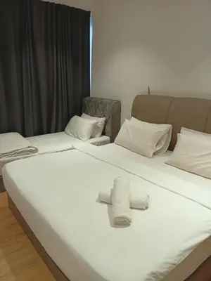 a white bed with a cross on top of it at Quill Residence relax Suites KLCC in Kuala Lumpur