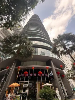 a tall building with red umbrellas in front of it at Vortex KLCC in Kuala Lumpur