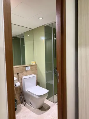 a bathroom with a toilet and a large mirror at Vortex KLCC in Kuala Lumpur