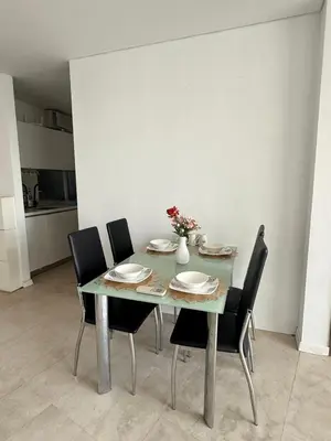 a dining room table with chairs and a vase with flowers at Vortex KLCC in Kuala Lumpur