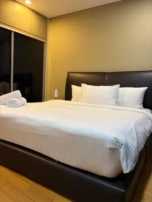 a large bed with white sheets and pillows at sky suites by towerview in Kuala Lumpur