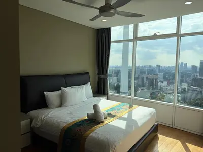 a bedroom with a bed and a large window at sky suites by towerview in Kuala Lumpur