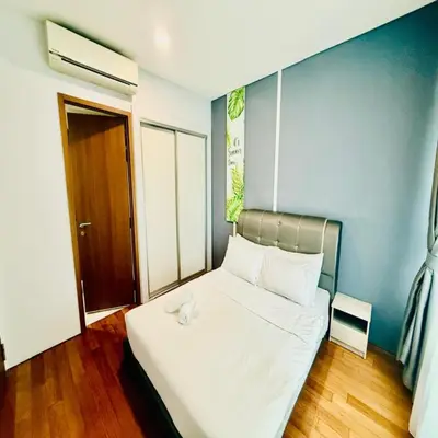 a bedroom with a white bed with a blue wall at sky suites klcc by Sweet home Apartment in Kuala Lumpur