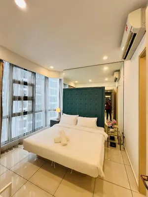 a bedroom with a large bed with a green headboard at Trion sky suite KL in Kuala Lumpur