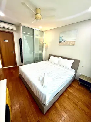 a bedroom with a large white bed with a candle on it at Vortex Suites Apartment Klcc in Kuala Lumpur