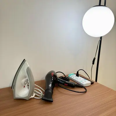 a desk with a phone and a lamp and a remote control at 30 OFF Monthly l Premium 3BR Suite in KLCC in Kuala Lumpur