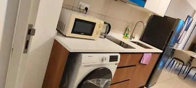 a kitchen with a washing machine and a microwave at Majestic Residence Klcc By DIVINA in Kuala Lumpur