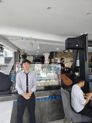 a man in a tie standing in front of a store at Scarletz Suites KLCC by cozy stay in Kuala Lumpur