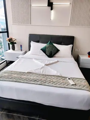 a bedroom with a large white bed with white pillows at Scarletz Suites KLCC by cozy stay in Kuala Lumpur