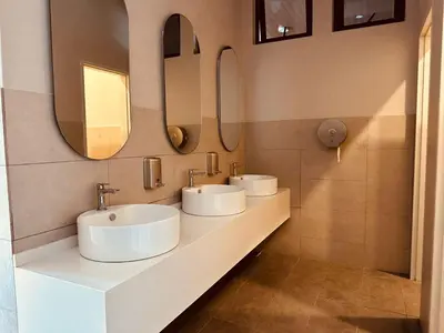 three sinks in a bathroom with two mirrors at Majestic Suites klcc By Falak in Kuala Lumpur